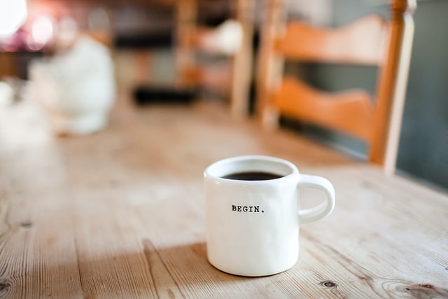 White coffee mug with the word, "Begin."