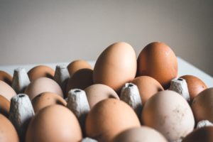 Closeup image of white and brown eggs in a carton. Federal bureau of prisons.
