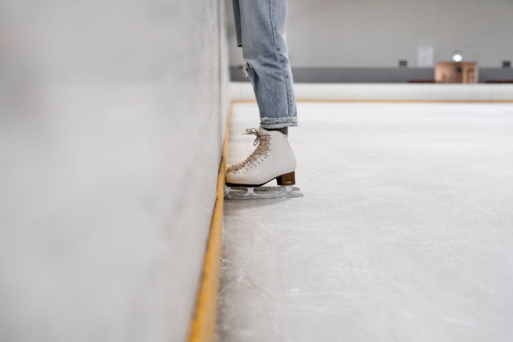 Person at ice rink wearing figure skates. City of Long Beach.