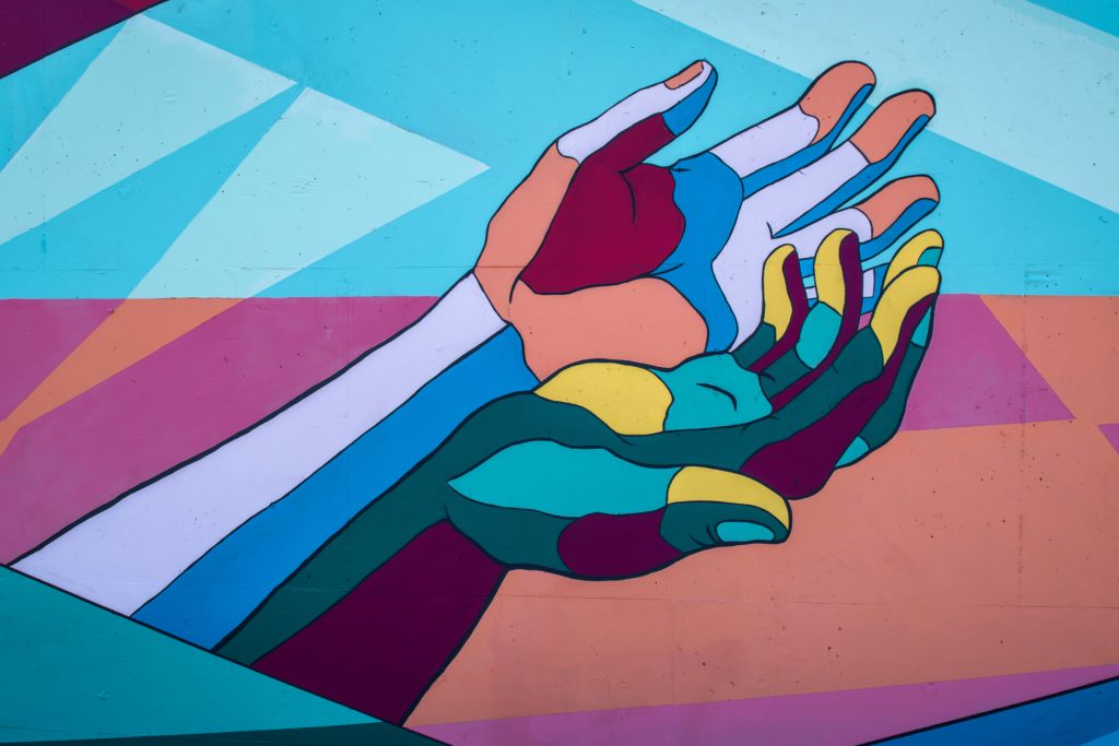 colorful mural of extended cupped hands. Mental health