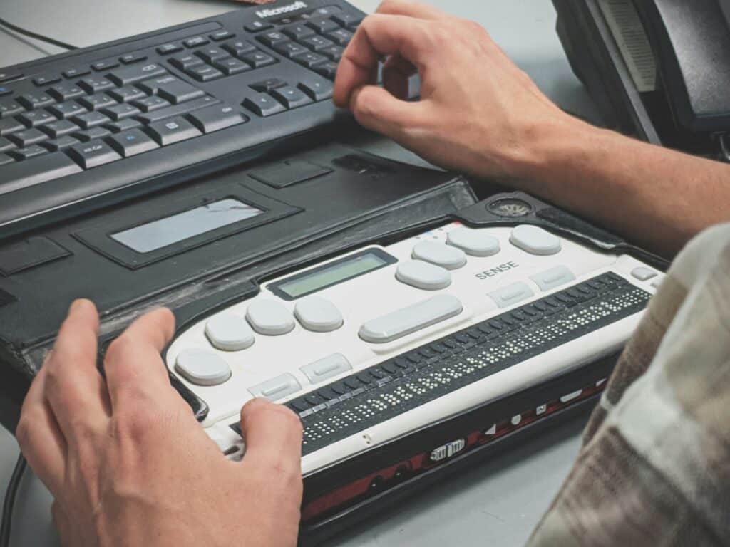 person using braille writer for accessible typing